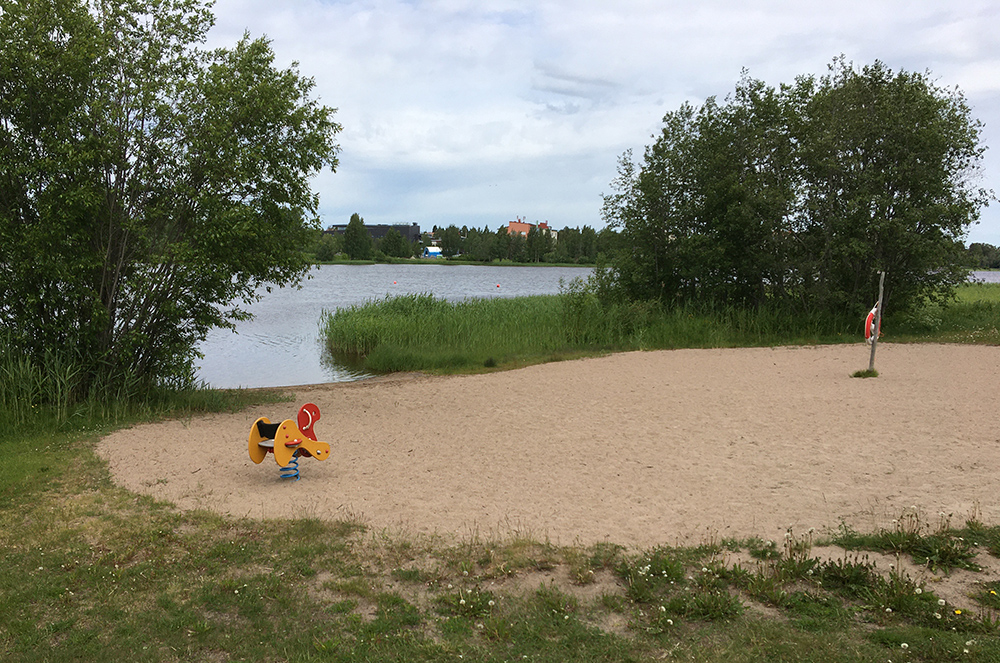 bild på sandstrand med lekgunga