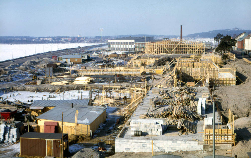 Vy över byggarbetsplats med trästommar till byggnader.